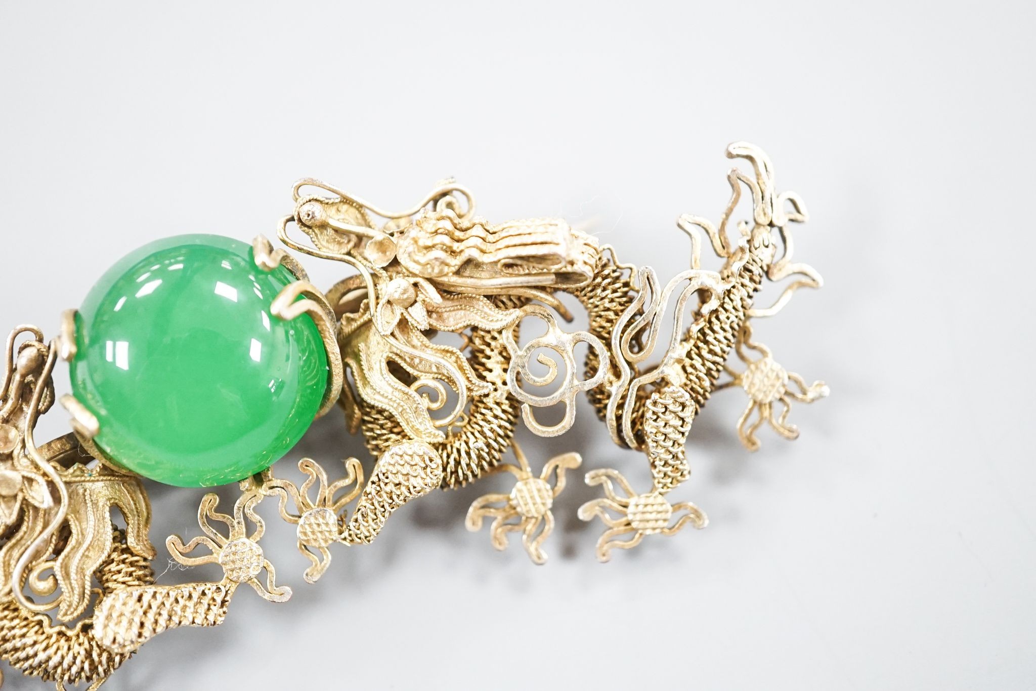 A Chinese gilt white metal and green cabochon set dragon brooch, 89mm.